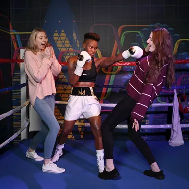 Guests pretend they're getting punched by Nicola Adams' wax figure in the ring at Madame Tussauds Blackpool