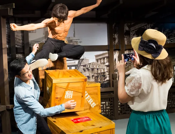 1 out of 4 experiences in Madame Tussauds Singapore. Tourist taking photo with Bruce Lee's wax figure.