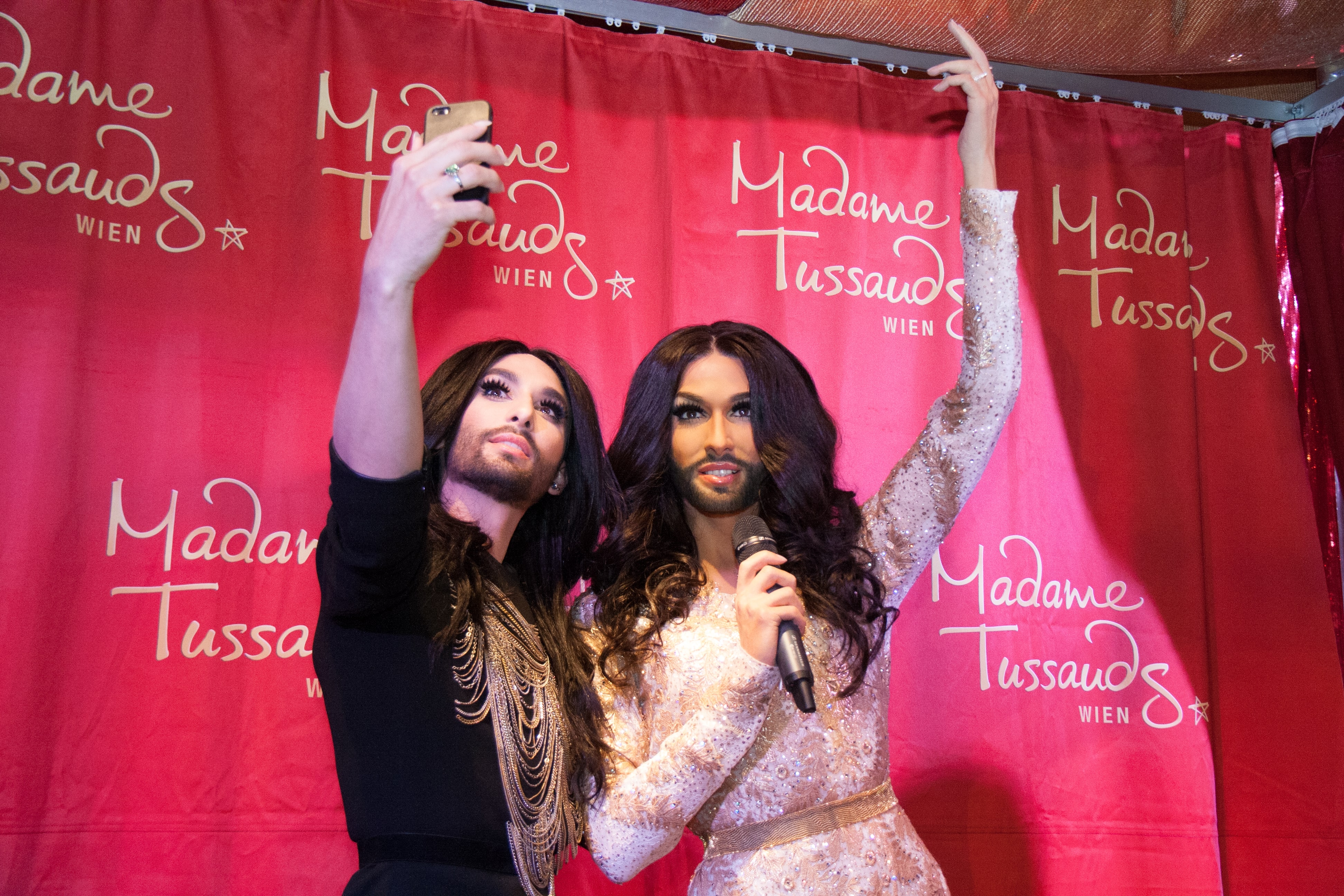 Conchita Wurst takes a selfie with herself.