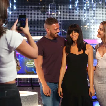 Guests stand next to Claudia Winkleman's wax figure while someone takes a photo