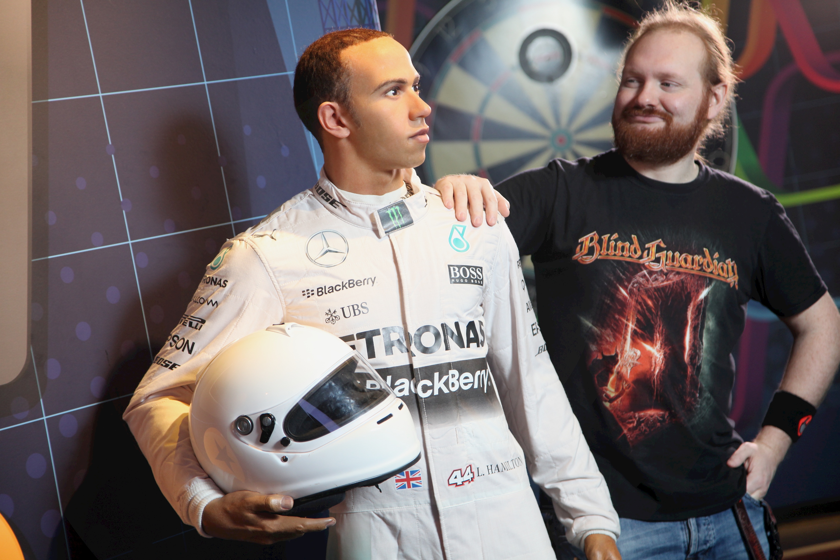 Guests stands next to Lewis Hamilton holding his helmet wax figure at Madame Tussauds Blackpool