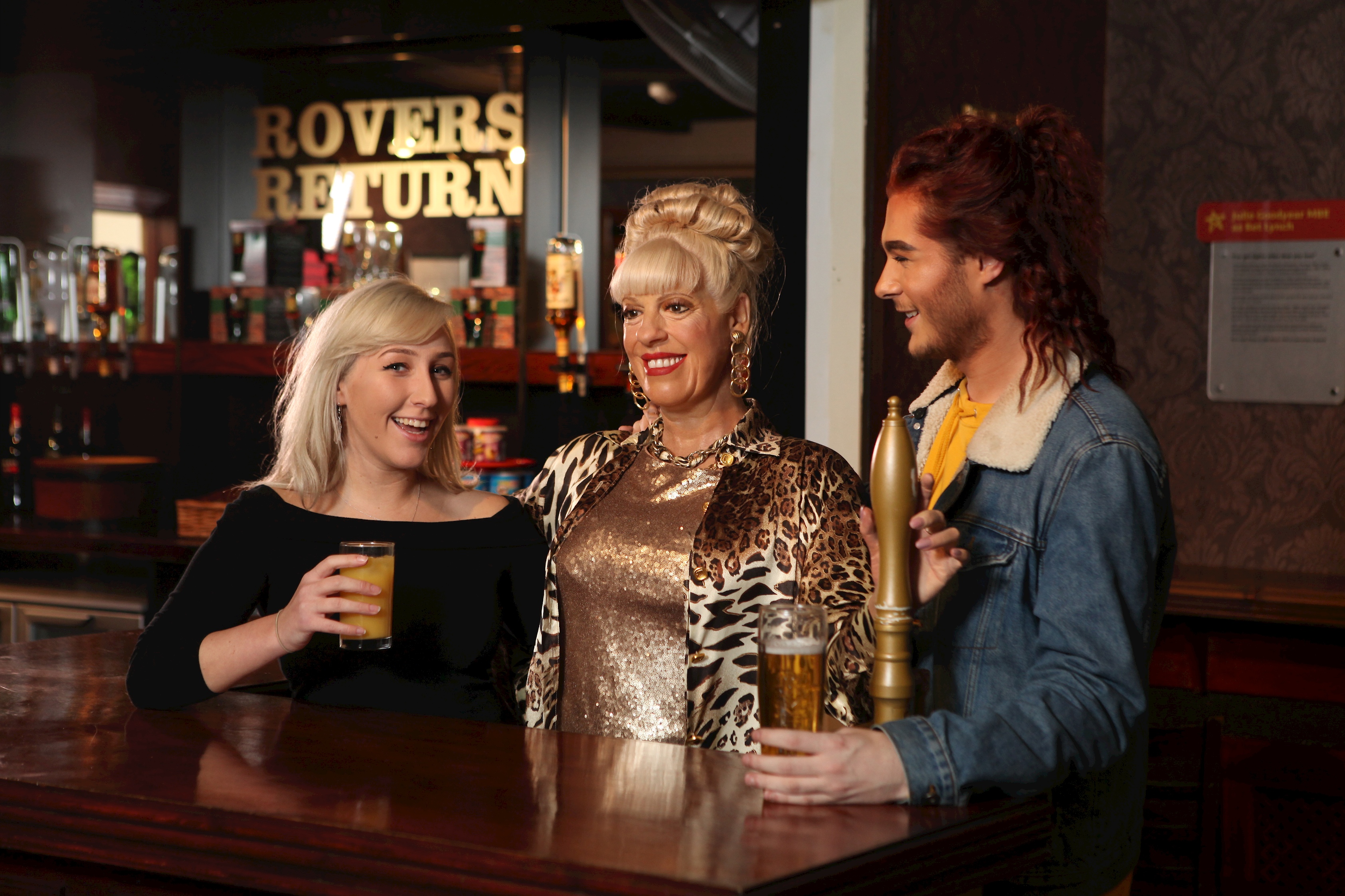 Guests having a drink with Bet Lynch's wax figure at Madame Tussauds Blackpool