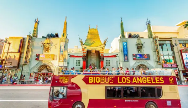 Big Bus Los Angeles tour bus passes by the iconic TCL Chinese Theatre on Hollywood Boulevard