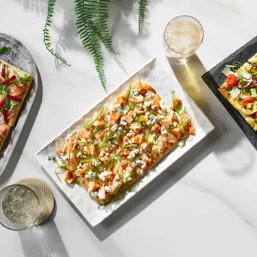 A trio of flatbreads. Smoked salmon flatbread, buffalo chicken flatbread, and grilled steak flatbread.
