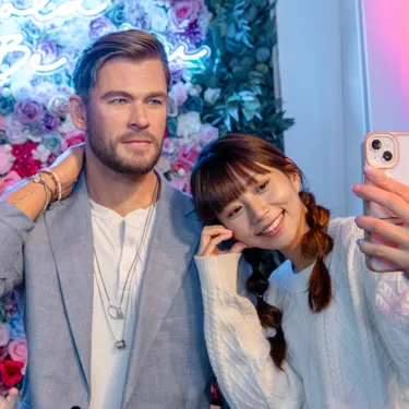 Chris Hemsworth wax figure in front of floral wall