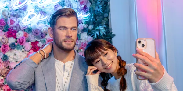 Chris Hemsworth wax figure in front of floral wall