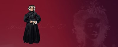 Wax figure of Madame Tussaud depicted wearing a black Victorian-style dress with intricate lace detailing and a high collar. The dress is incredibly detailed with folds and layers, making it a lifelike representation of Madame Tussaud in her Victorian era attire.