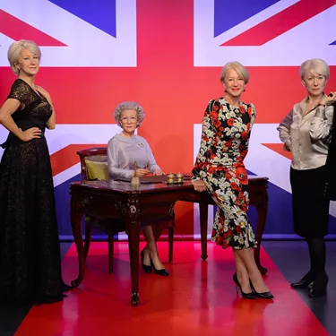 Dame Helen Mirren with her figures at Madame Tussauds London
