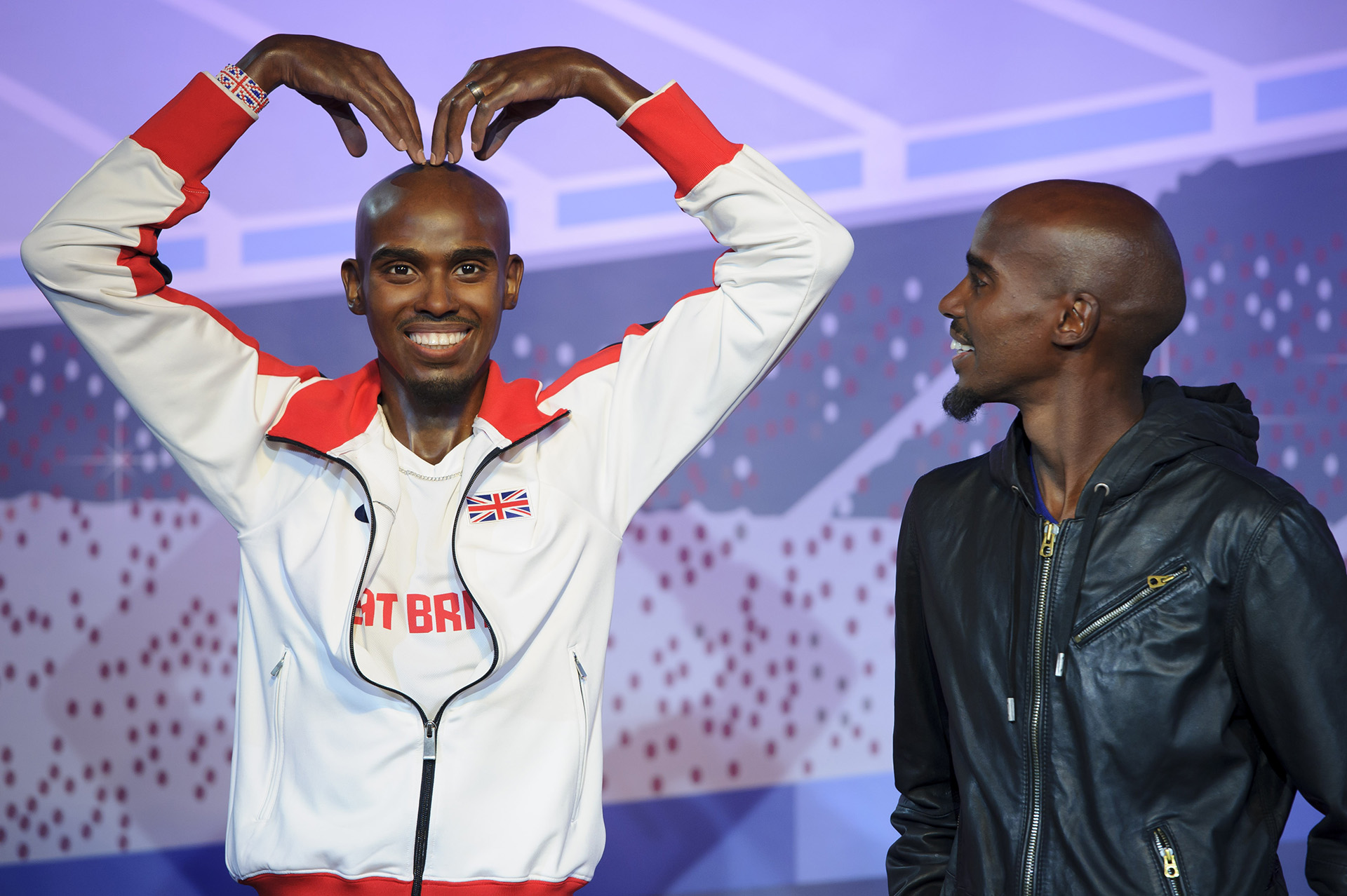 Mo Farah looking at his own figure at Madame Tussauds London
