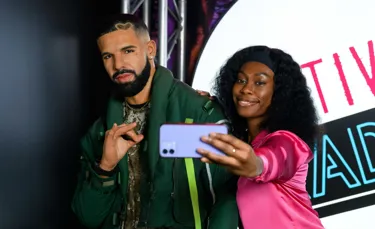 Visitor taking a selfie with Drake figure