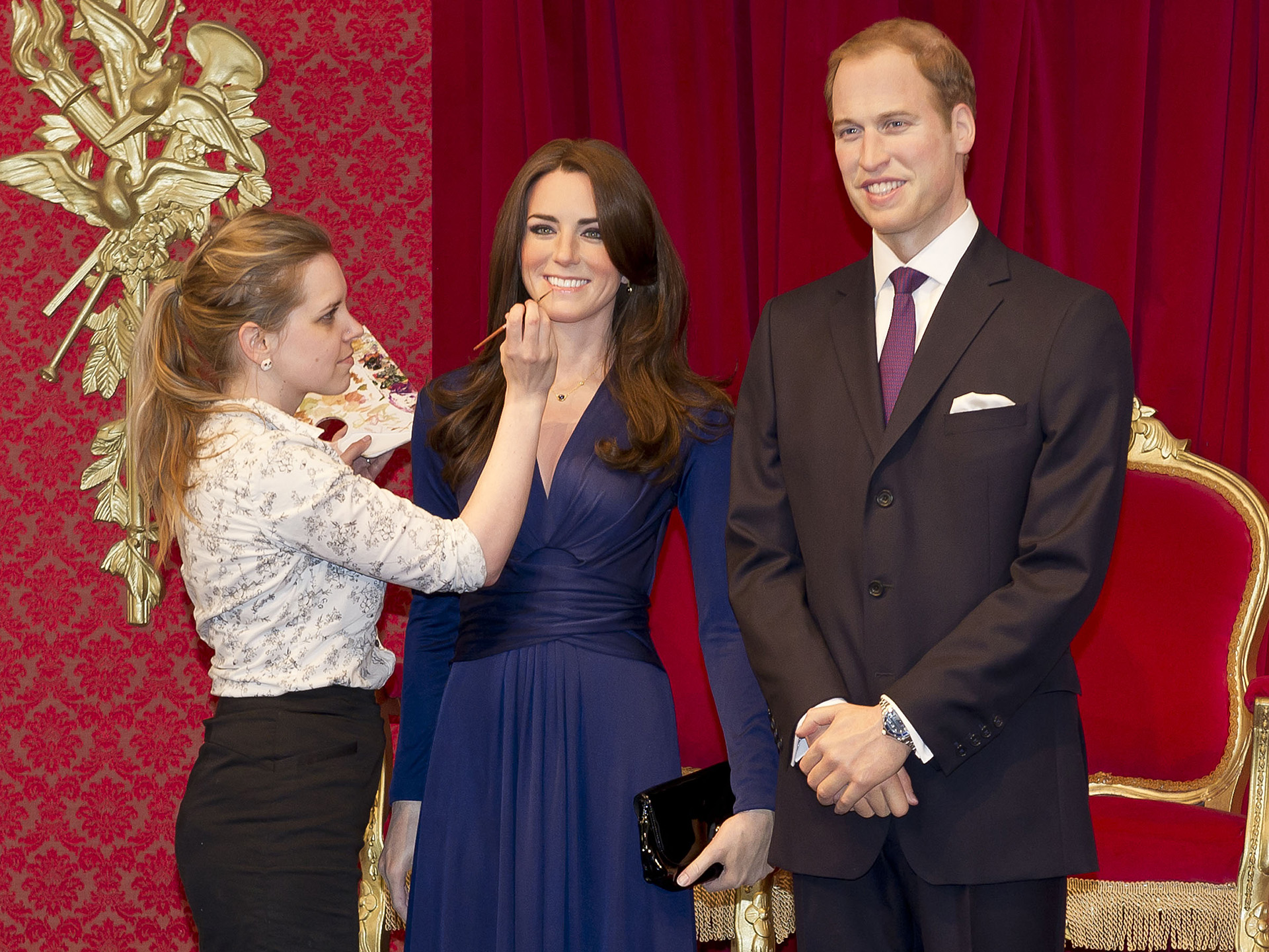 Sculptor touching up Kate & William figures