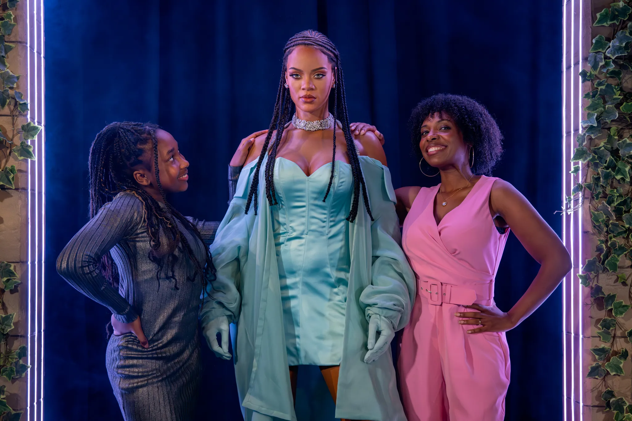 A mother and daughter stood next to a figure of Rihanna