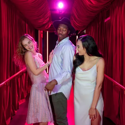 Three people walking down a red carpet