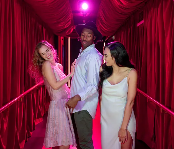 Three people walking down a red carpet