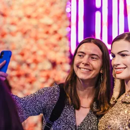 guest taking photo with Anne Hathaway wax figure