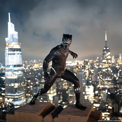 Figura de cera de Black Panther en un tejado con el horizonte nocturno de Nueva York.