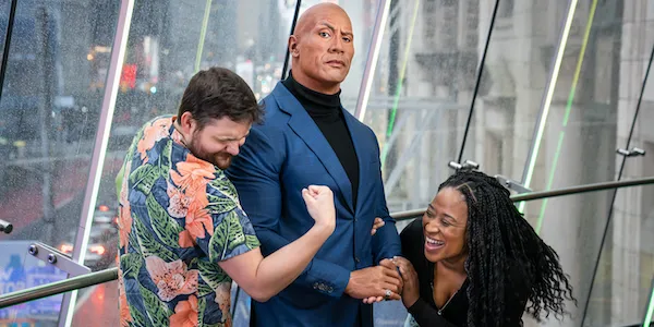 Dois visitantes posam e mostram os músculos ao lado da figura de cera de Dwayne “The Rock” Johnson no Madame Tussauds Nova York.