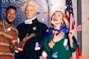 Guests posing with a wax figure of George Washington and confetti is falling down