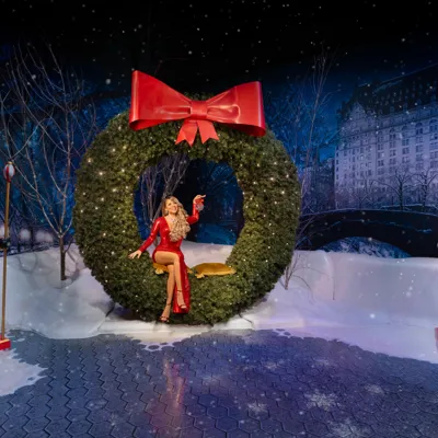 Figura de cera de Mariah Carey no Madame Tussauds Nova York, ladeada por figuras de quebra-nozes de cada lado.