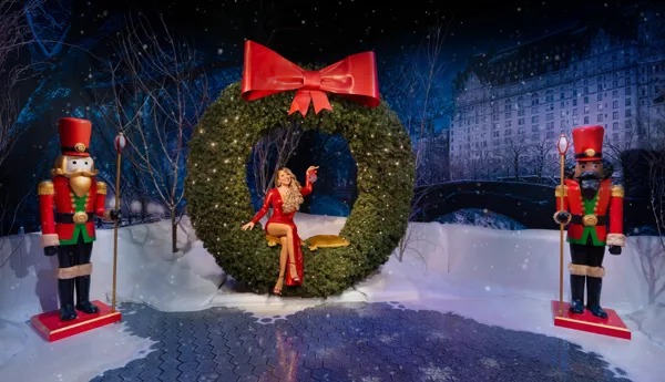 Figura de cera de Mariah Carey no Madame Tussauds Nova York, ladeada por figuras de quebra-nozes de cada lado.