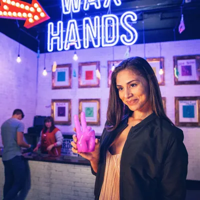 Visitante segurando uma réplica em cera personalizada da sua mão no Madame Tussauds Nova York.