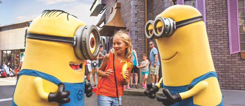 A kid interacting with Despicable Me Minions at Universal Studios.
