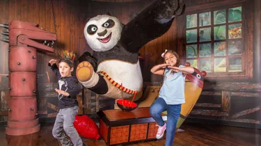 Two kids in kung fu stances along side Po from the movie Kung Fu Panda