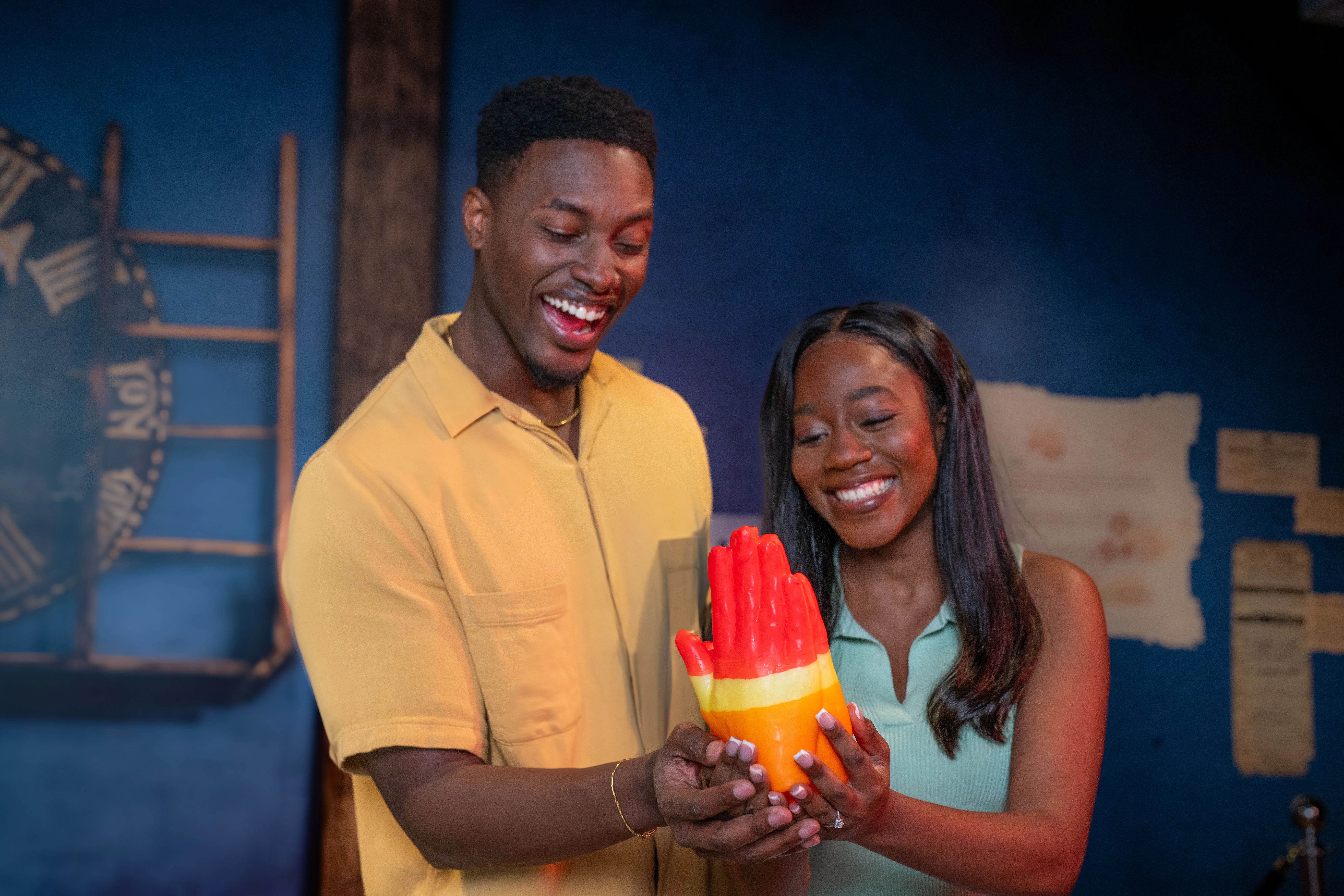 Couple smiles at wax hands they made together at Madame Tussauds Orlando.
