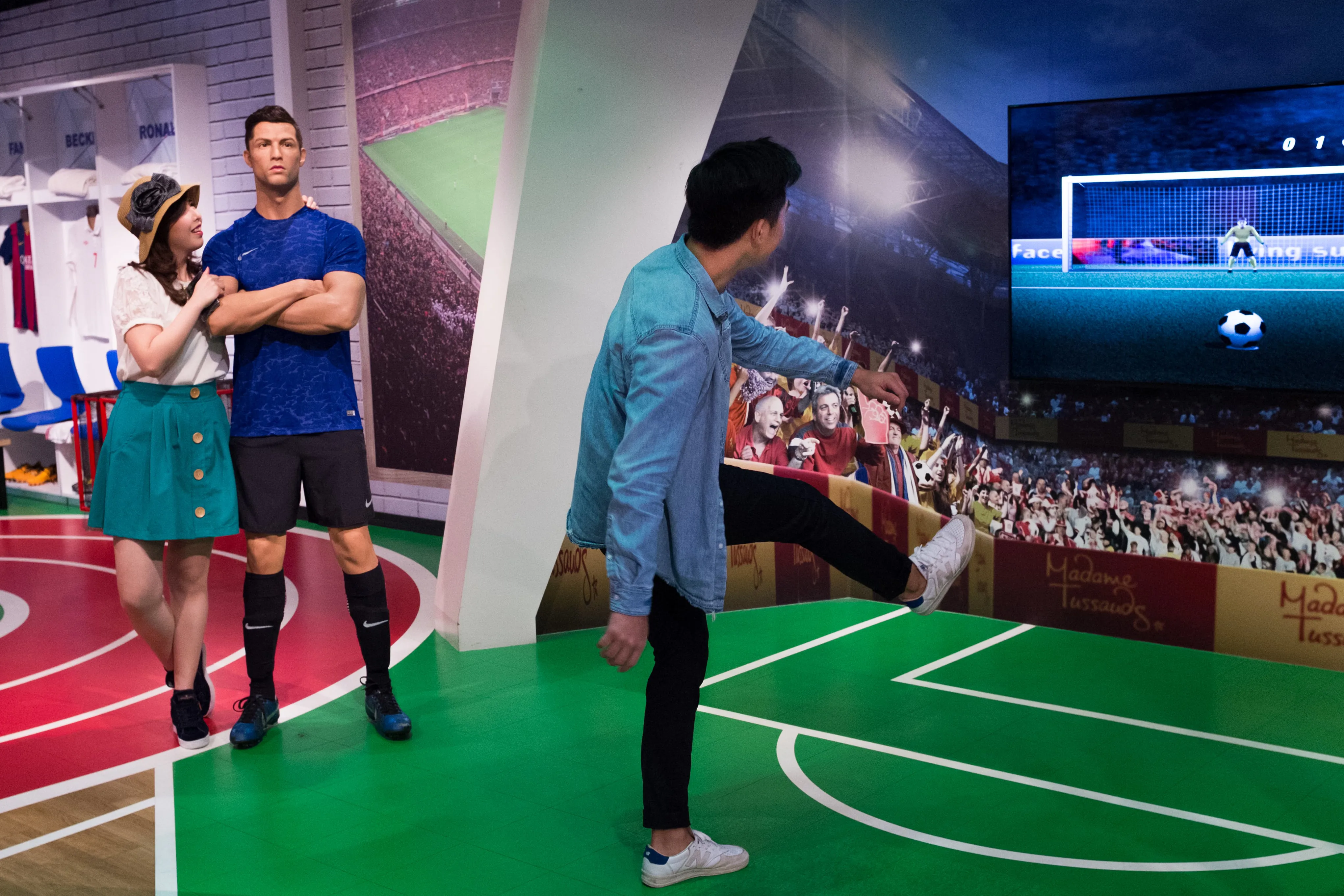 Visitors at Madame Tussauds Singapore Sports Zone taking pictures with the wax figure of footballer Cristiano Ronaldo. 