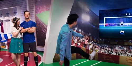 Visitors at Madame Tussauds Singapore Sports Zone taking pictures with the wax figure of footballer Cristiano Ronaldo.