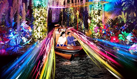 Spirit of Singapore boat ride at Madame Tussauds Singapore - A boat with people sitting inside, passing by figures of iconic Singapore landmarks in a colorful and immersive environment