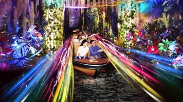Spirit of Singapore boat ride at Madame Tussauds Singapore - A boat with people sitting inside, passing by figures of iconic Singapore landmarks in a colorful and immersive environment