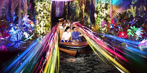 Spirit of Singapore boat ride at Madame Tussauds Singapore - A boat with people sitting inside, passing by figures of iconic Singapore landmarks in a colorful and immersive environment