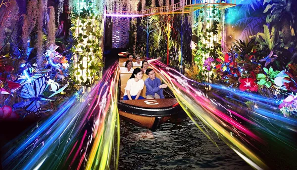 Spirit of Singapore boat ride at Madame Tussauds Singapore - A boat with people sitting inside, passing by figures of iconic Singapore landmarks in a colorful and immersive environment