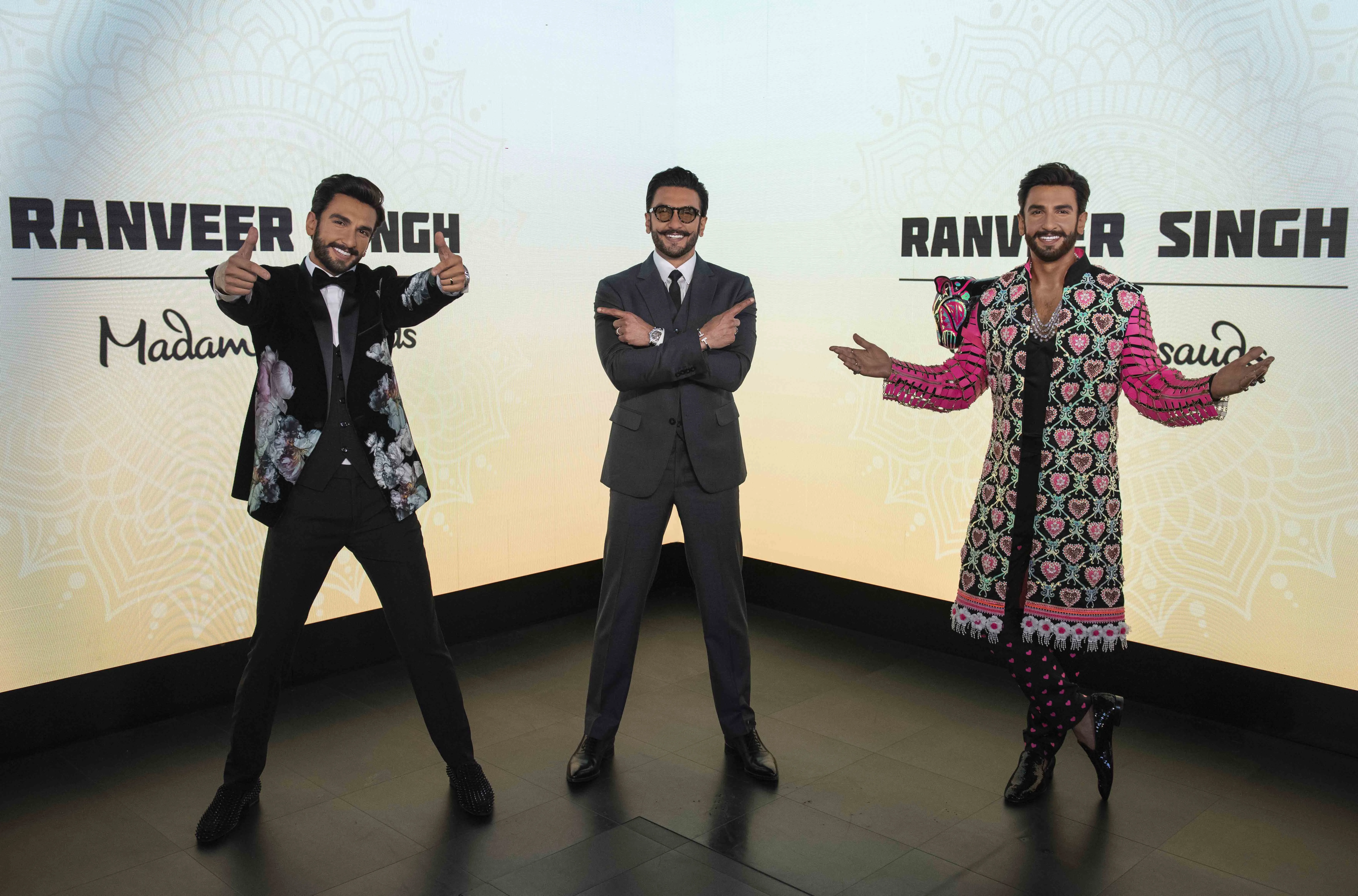 At Madame Tussauds are two Ranveer Singh wax figure replicas. The Bollywood's celebrity and actor visited his wax statues, posing with arms crossed and pointing at the two figures, showcasing their exceptional craftsmanship.