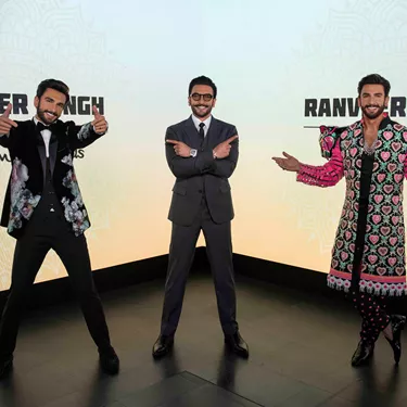 At Madame Tussauds are two Ranveer Singh wax figure replicas. The Bollywood's celebrity and actor visited his wax statues, posing with arms crossed and pointing at the two figures, showcasing their exceptional craftsmanship.