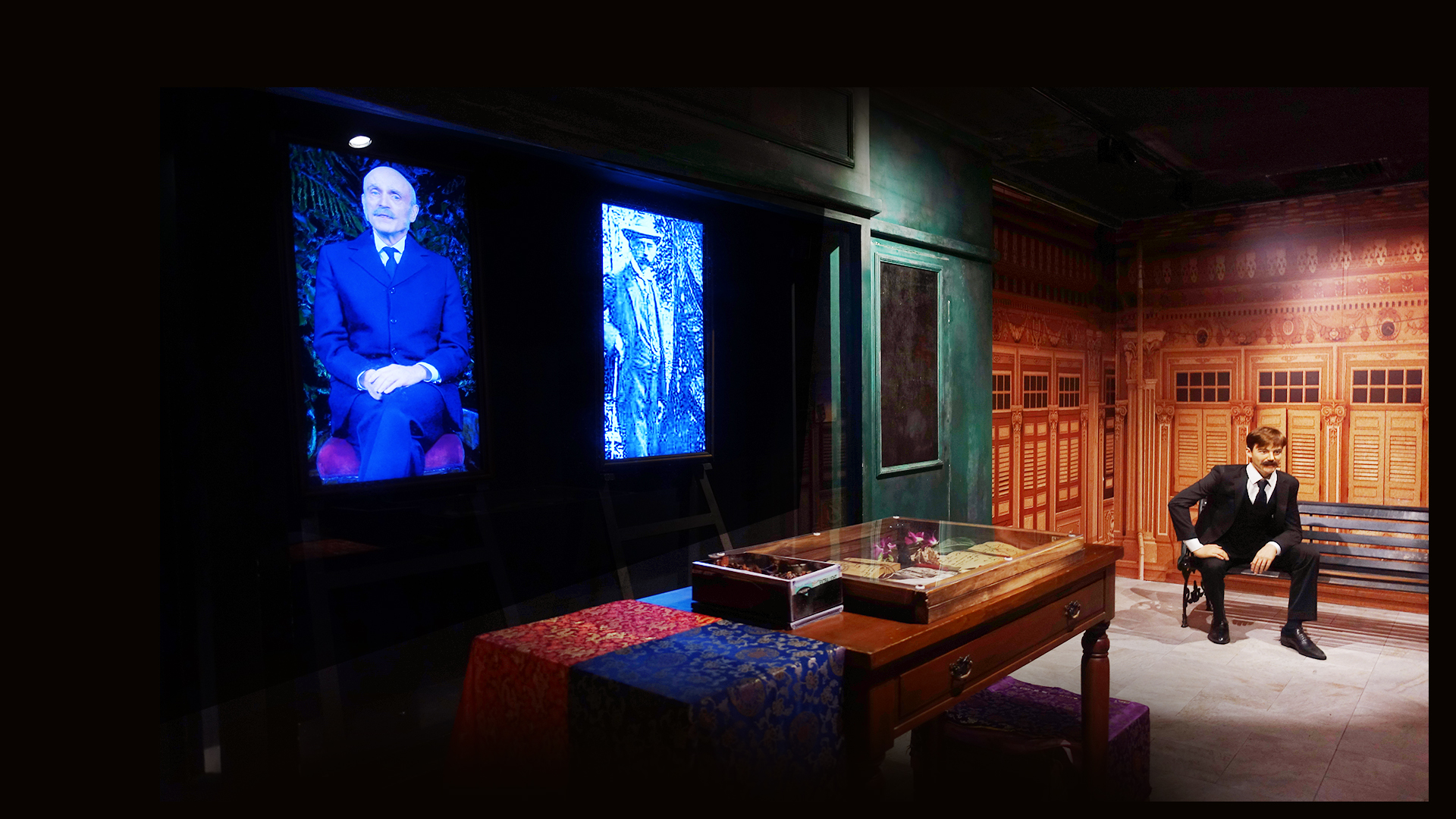 A man in suit is sitting on a bench with a hand propped on his leg. He is sitting in Singapore's financial hub and business centre back in 1823, Commercial Square. This is part of Images of Singapore exhibition in Madame Tussauds Singapore.