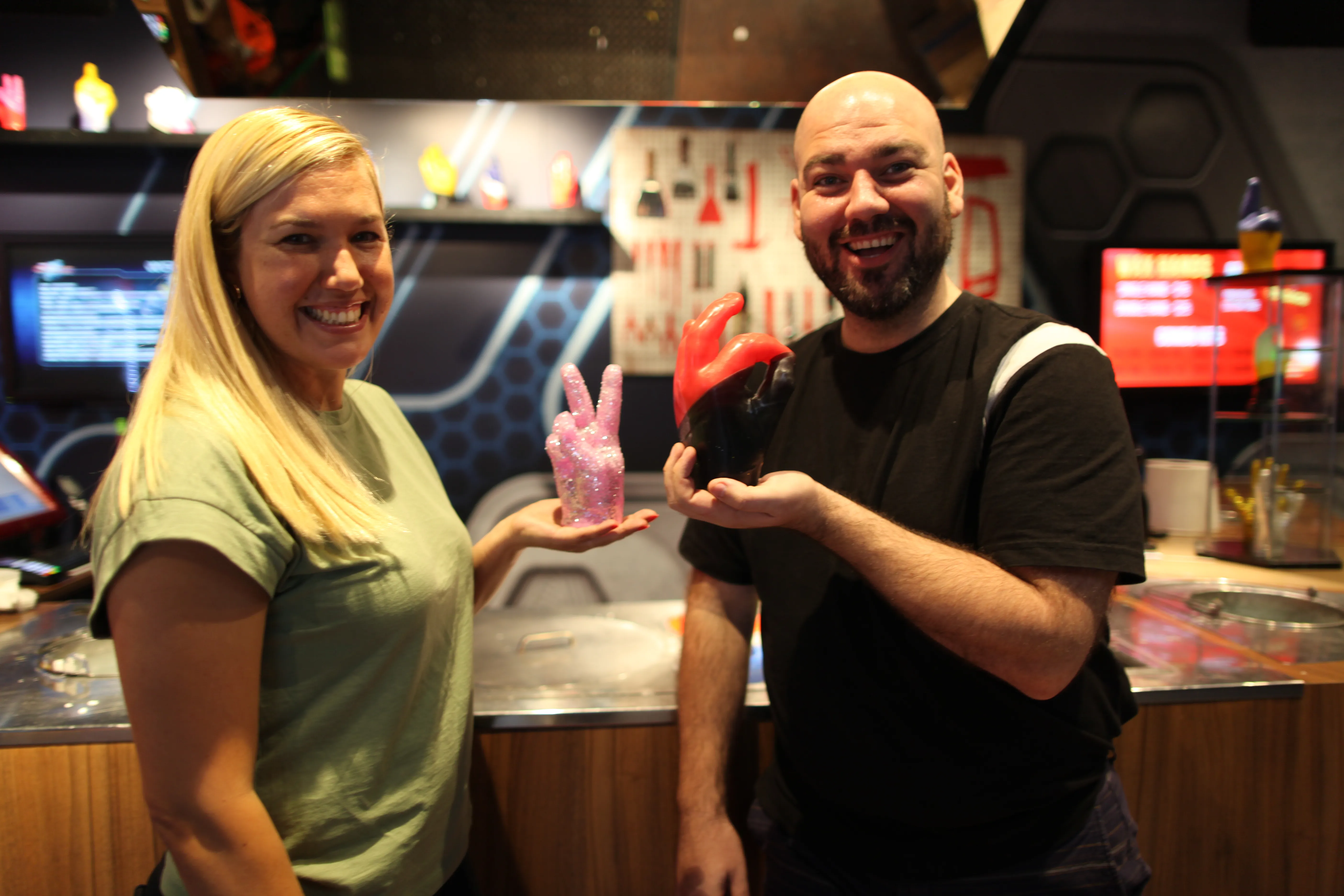 people smiling holding wax hands