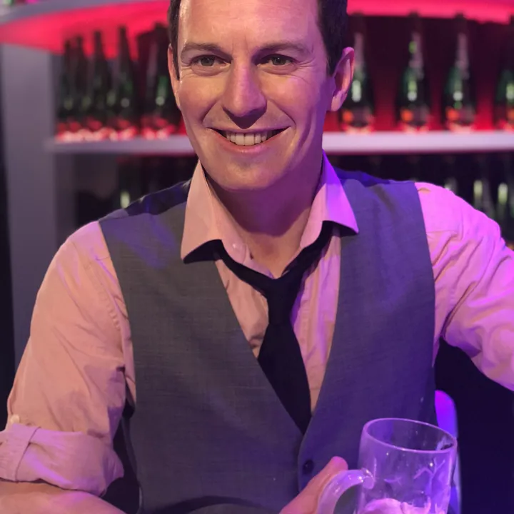 rove mcmanus waxwork at bar with drink