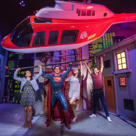 family holding up helicopter with superman
