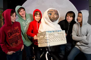 kids dressed in hoodies with E.T wax figure and bike