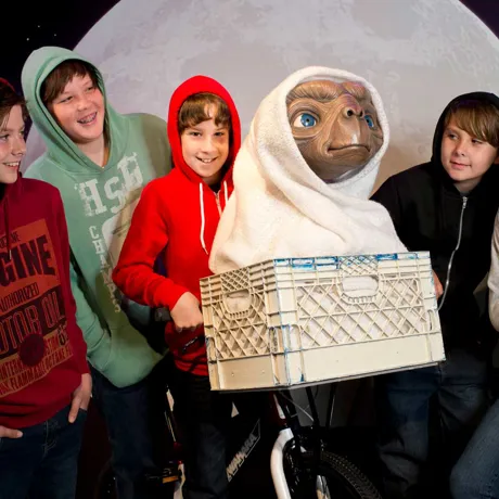 kids dressed in hoodies with E.T wax figure and bike