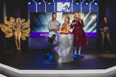 man and woman holding trophy on stage