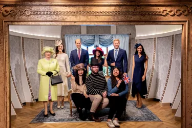 group of people posing with wax figures of the royal family