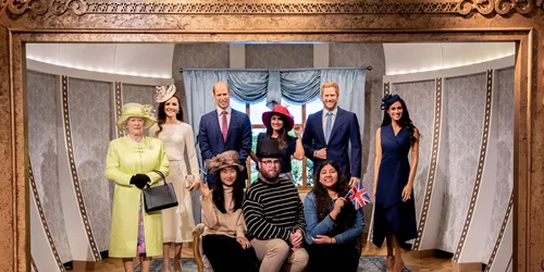 group of people posing with wax figures of the royal family