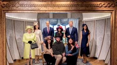 group of people posing with wax figures of the royal family