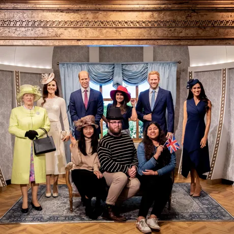 group of people posing with wax figures of the royal family
