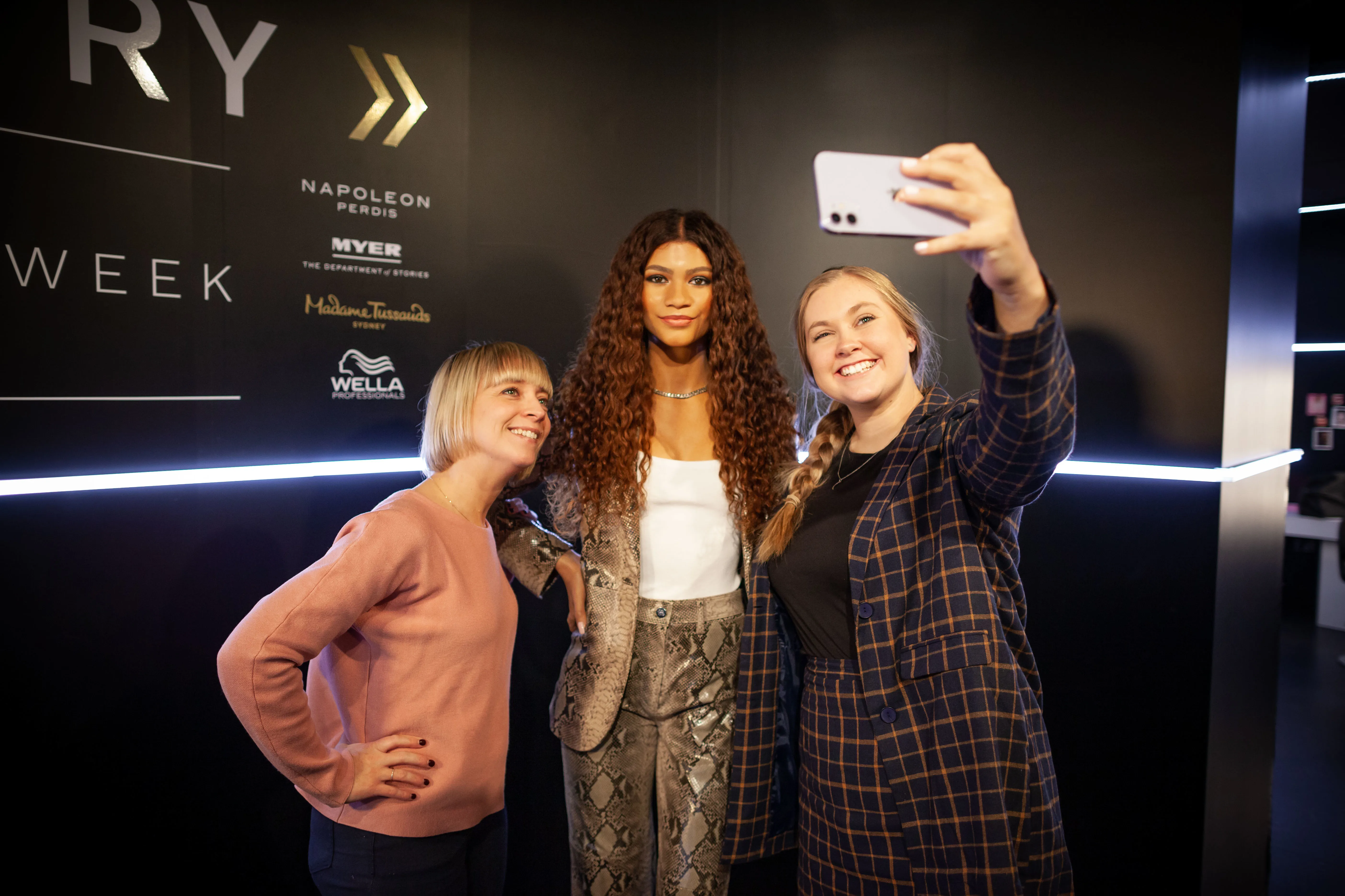 people taking a picture with zendeya wax figure