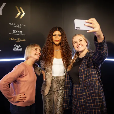 people taking a picture with zendeya wax figure