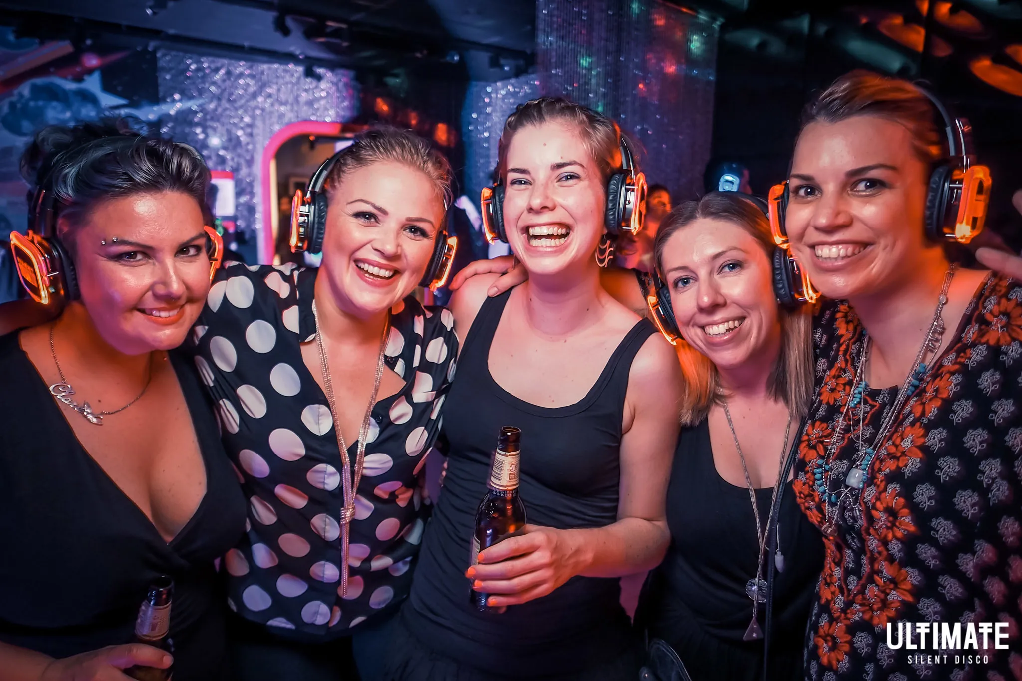 group of friends with headphones in silent disco